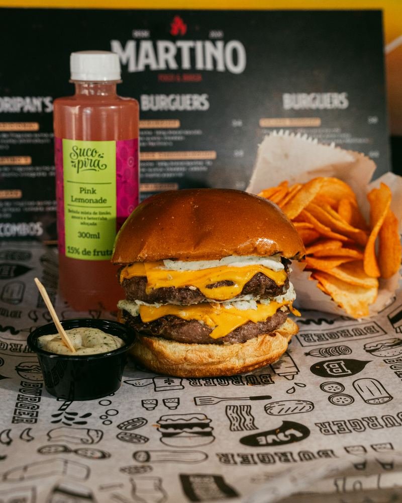 Hambúrguer servido com batata chips e suco Pira Natural